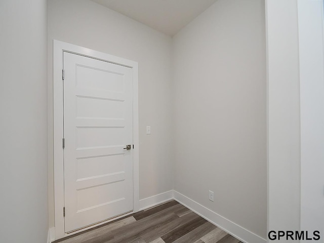 doorway featuring baseboards and dark wood-style flooring