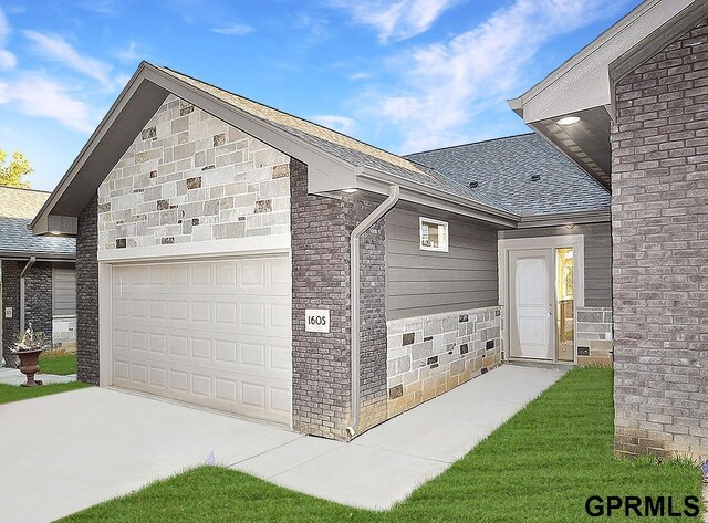 exterior space featuring a garage, a shingled roof, driveway, and brick siding
