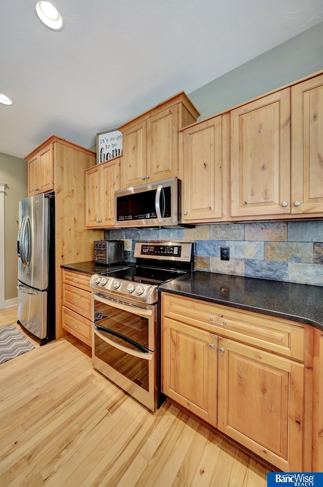 kitchen featuring appliances with stainless steel finishes, light brown cabinetry, light wood-style flooring, tasteful backsplash, and recessed lighting