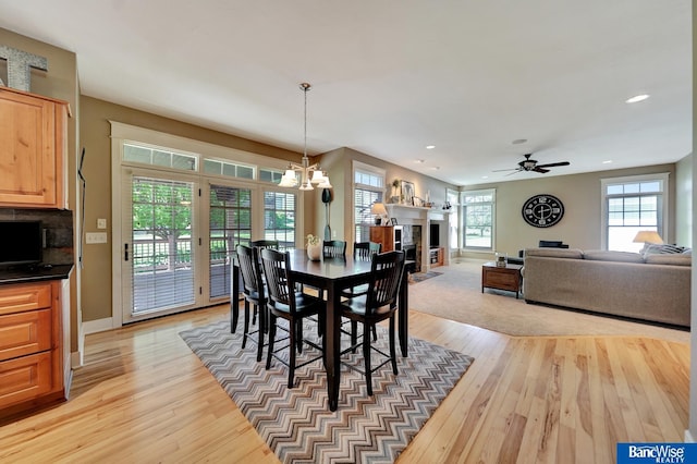 dining area with light wood finished floors, recessed lighting, baseboards, a chandelier, and ceiling fan