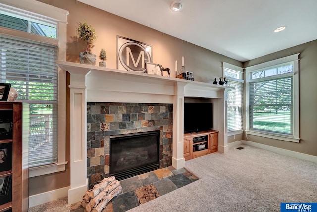 carpeted living room featuring a fireplace, plenty of natural light, and baseboards