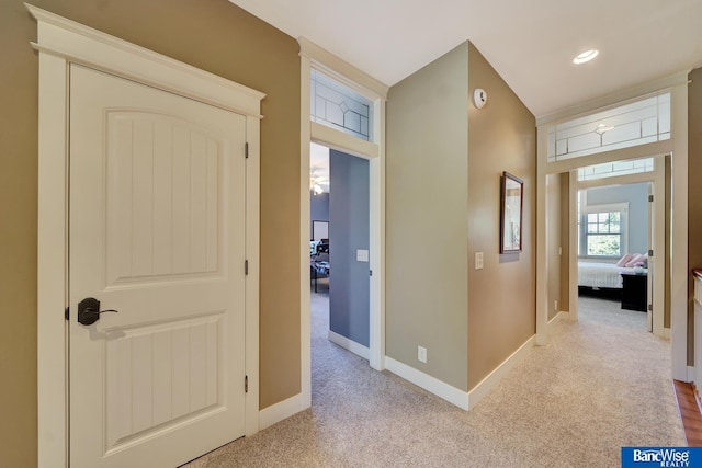 corridor with baseboards, light carpet, and recessed lighting