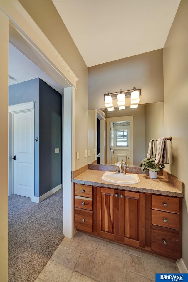 bathroom with baseboards, vanity, and stone finish flooring