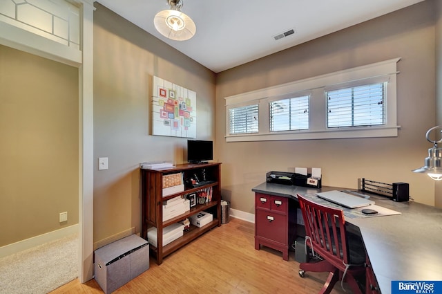 office area with light wood-style floors and baseboards