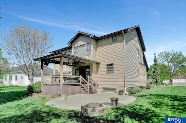 back of property featuring a fire pit, a patio area, a ceiling fan, and a yard