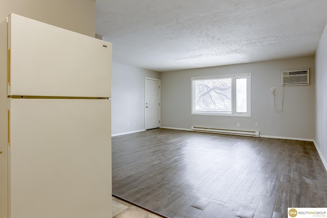interior space featuring baseboards, a baseboard radiator, a wall mounted AC, and wood finished floors
