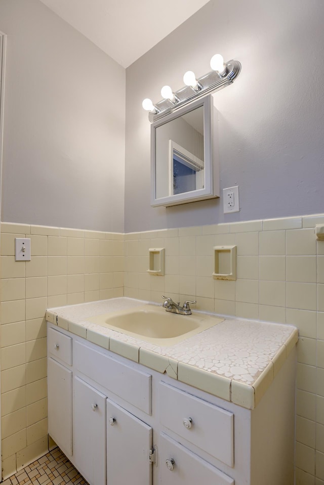 bathroom featuring tile walls, a wainscoted wall, and vanity