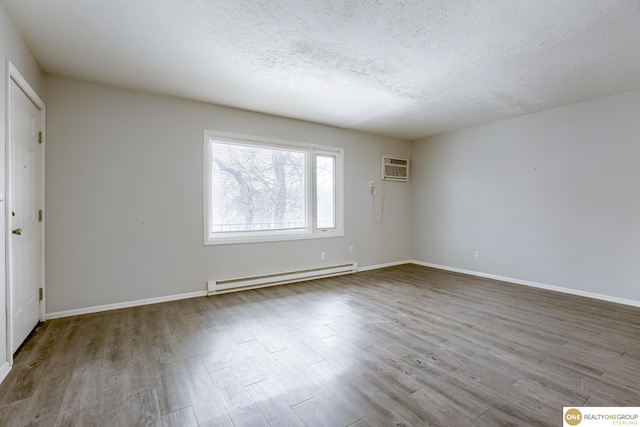 interior space with a textured ceiling, a baseboard radiator, baseboards, and wood finished floors
