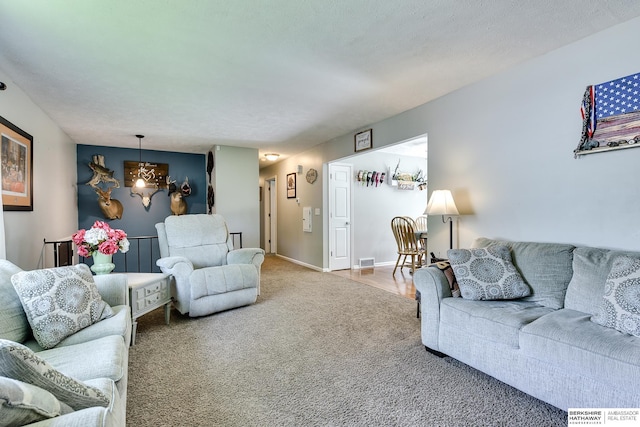 carpeted living area with visible vents and an inviting chandelier