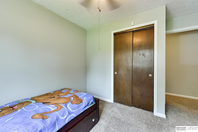 carpeted bedroom with baseboards, ceiling fan, and a closet