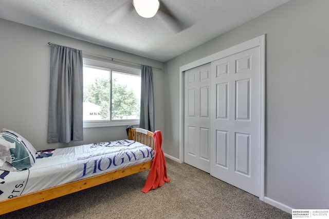 carpeted bedroom with a textured ceiling, a ceiling fan, baseboards, visible vents, and a closet