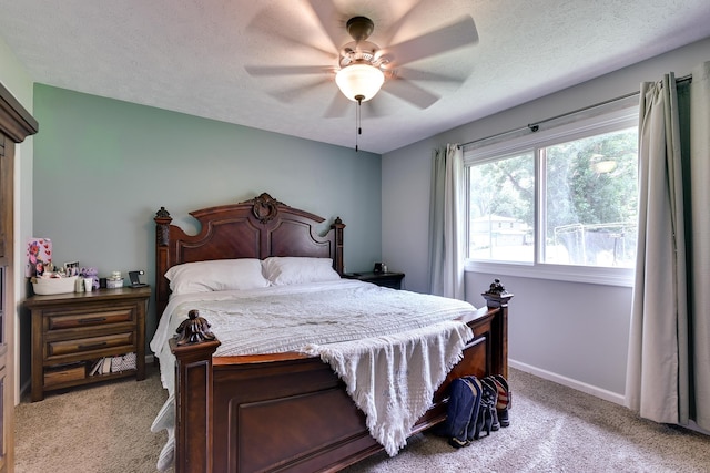 carpeted bedroom with a ceiling fan, baseboards, and a textured ceiling