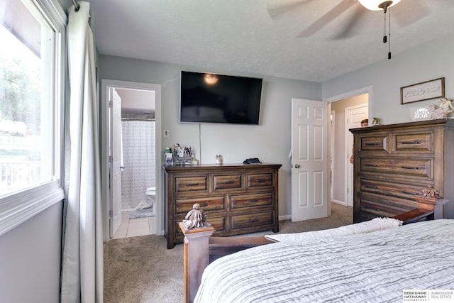 bedroom with carpet floors, baseboards, and ensuite bath