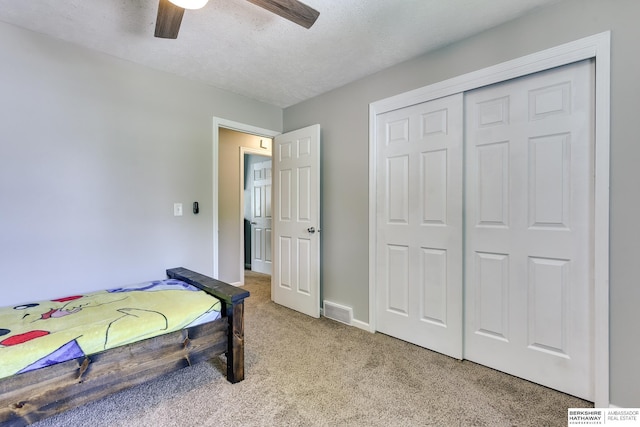 bedroom featuring light colored carpet, a ceiling fan, baseboards, visible vents, and a closet