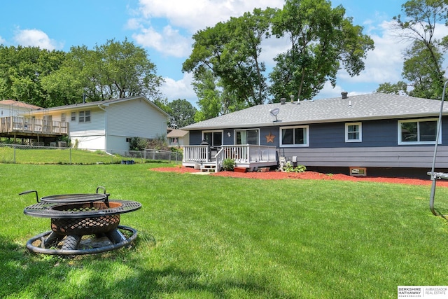 back of house with a lawn, fence, an outdoor fire pit, and a deck