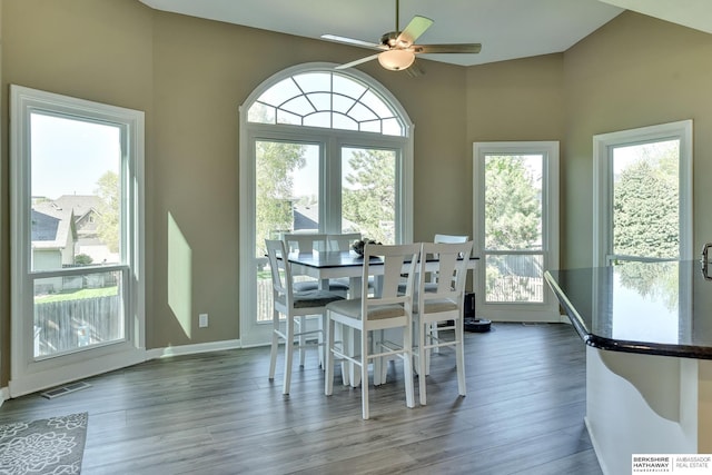 dining area with visible vents, a ceiling fan, lofted ceiling, and wood finished floors