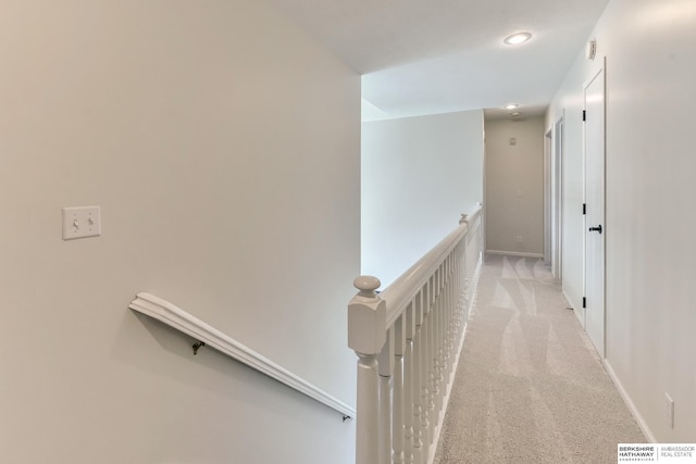 hall with recessed lighting, carpet, baseboards, and an upstairs landing