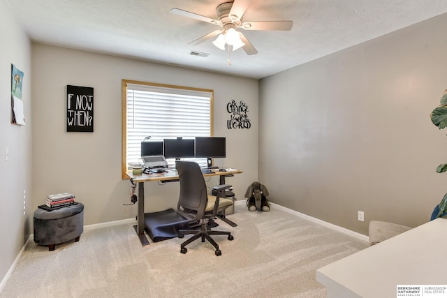 carpeted office space with baseboards, a ceiling fan, and visible vents