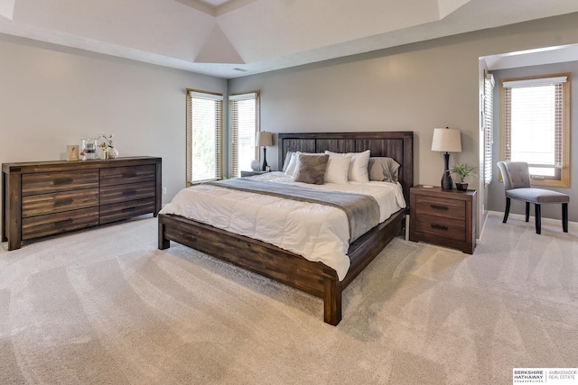 carpeted bedroom featuring baseboards and multiple windows