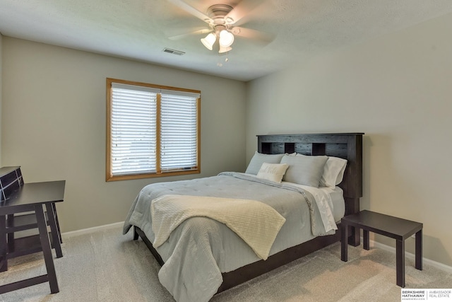 bedroom with baseboards, visible vents, and light carpet