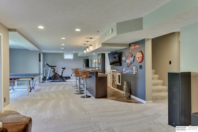 kitchen with carpet floors, baseboards, open floor plan, a breakfast bar area, and recessed lighting