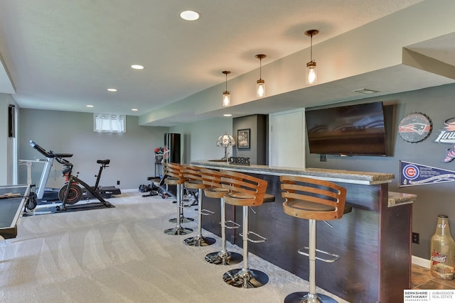 bar with carpet floors, baseboards, indoor bar, recessed lighting, and hanging light fixtures