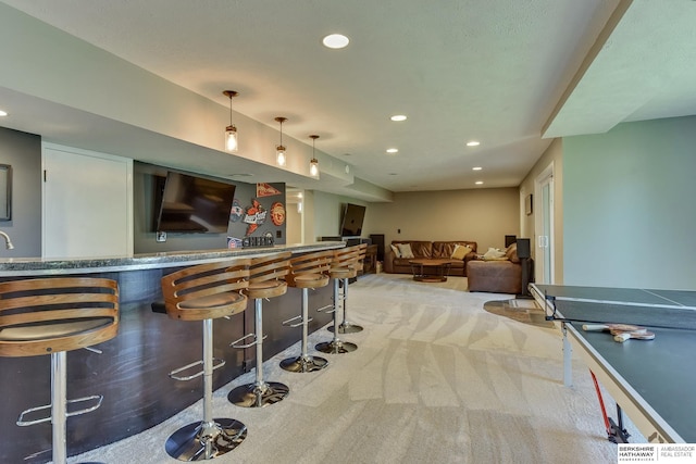 bar with indoor wet bar, recessed lighting, decorative light fixtures, and light colored carpet