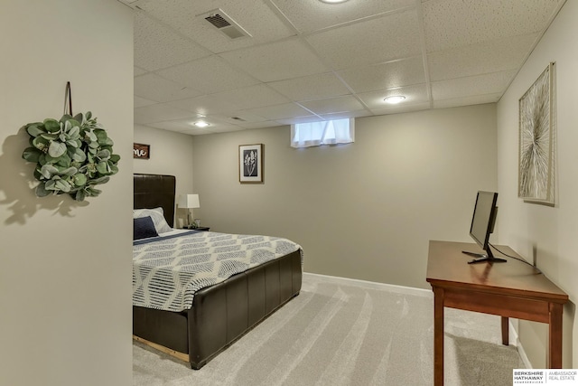 bedroom with baseboards, visible vents, a drop ceiling, and light carpet