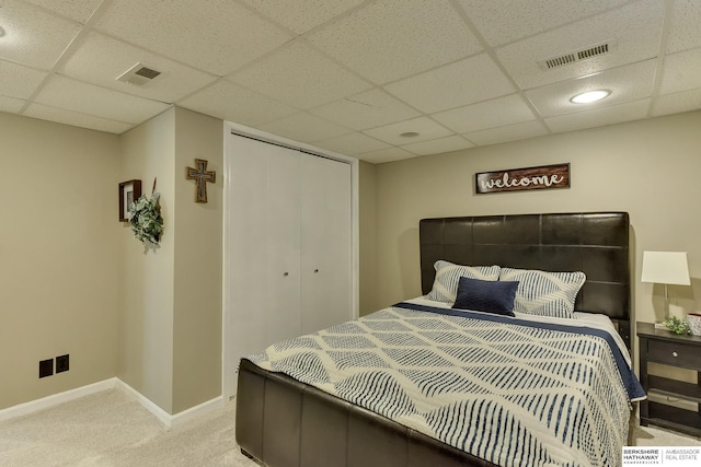 bedroom with visible vents, light carpet, and a paneled ceiling