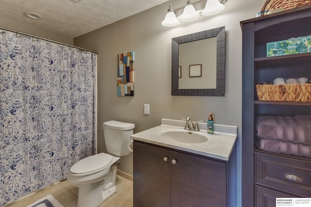 bathroom with a textured ceiling, tile patterned flooring, vanity, baseboards, and toilet