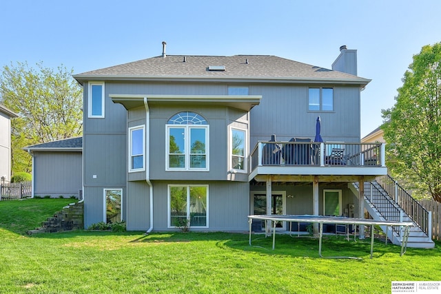 back of property featuring stairs, a lawn, a wooden deck, and a chimney