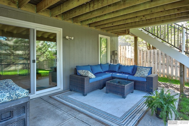 view of patio with outdoor lounge area, fence, and stairway