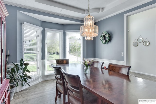 dining room featuring plenty of natural light, light wood finished floors, and a notable chandelier