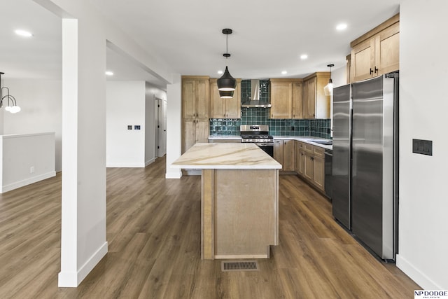 kitchen featuring wall chimney range hood, baseboards, stainless steel appliances, and visible vents