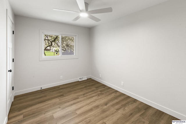 empty room featuring baseboards, ceiling fan, and wood finished floors