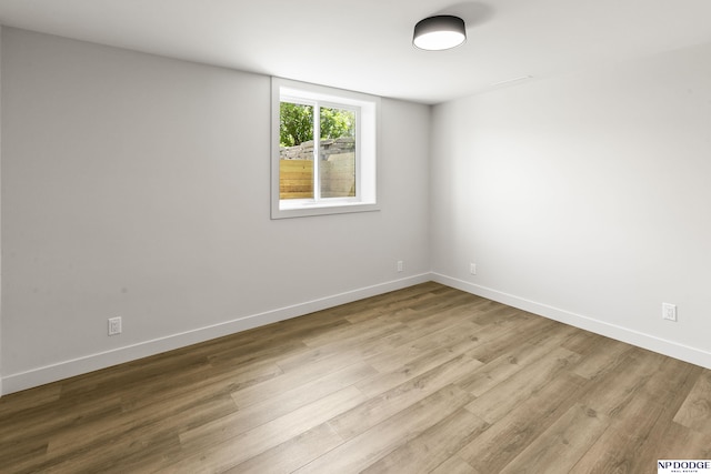 empty room featuring baseboards and wood finished floors