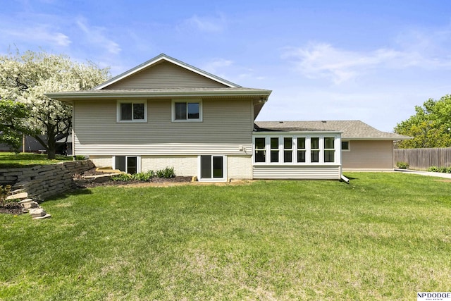 rear view of property with fence and a yard