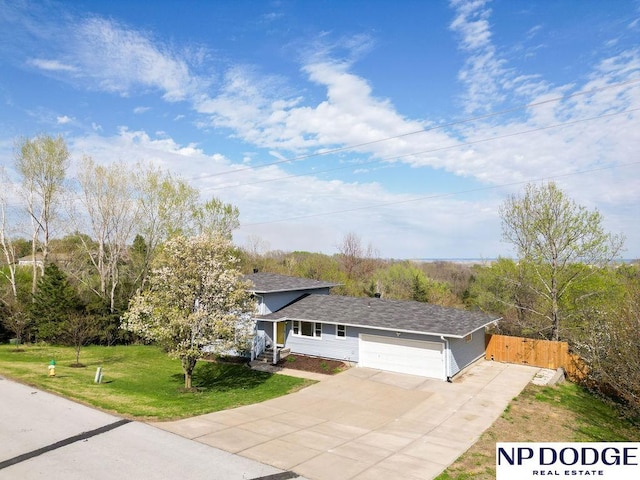 view of front of house featuring driveway, fence, a front lawn, an attached garage, and a shingled roof