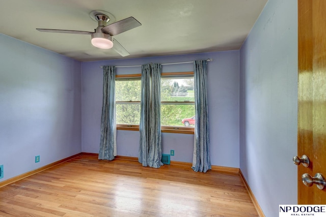 unfurnished room with baseboards, ceiling fan, and light wood-type flooring