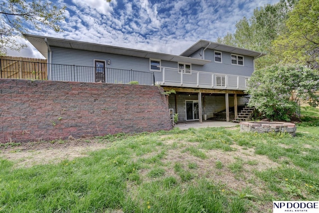 rear view of property featuring a patio area, a wooden deck, stairway, and fence