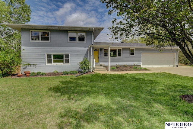 split level home featuring an attached garage, a front lawn, and driveway