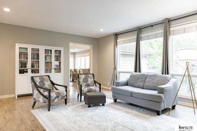 living area featuring recessed lighting, baseboards, and light wood-type flooring