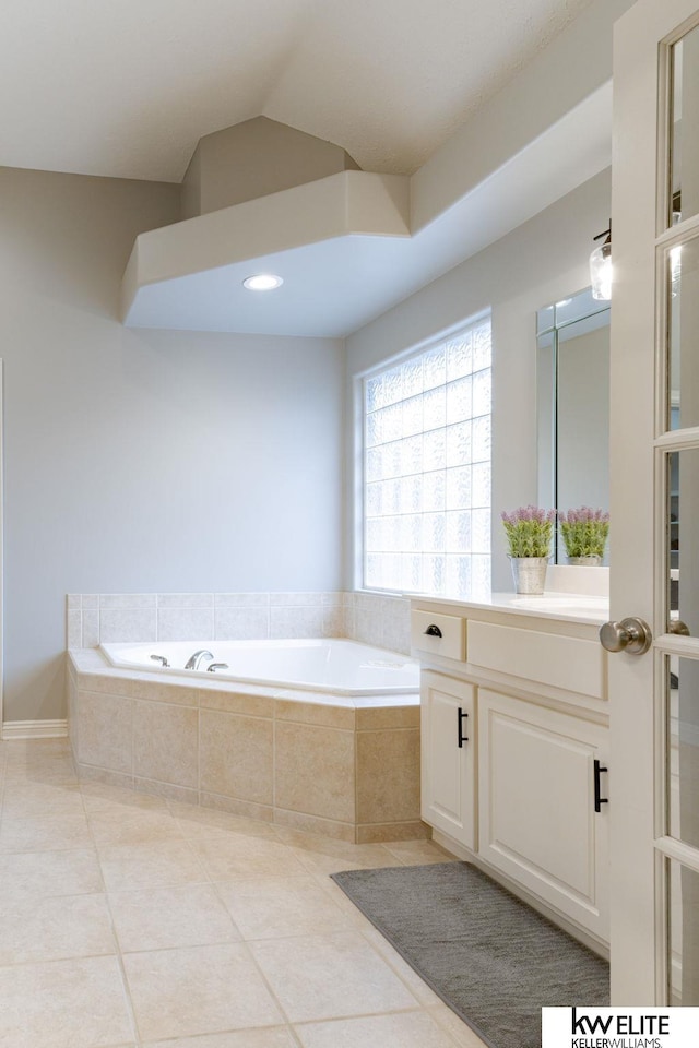 full bathroom featuring tile patterned flooring, a bath, and vanity