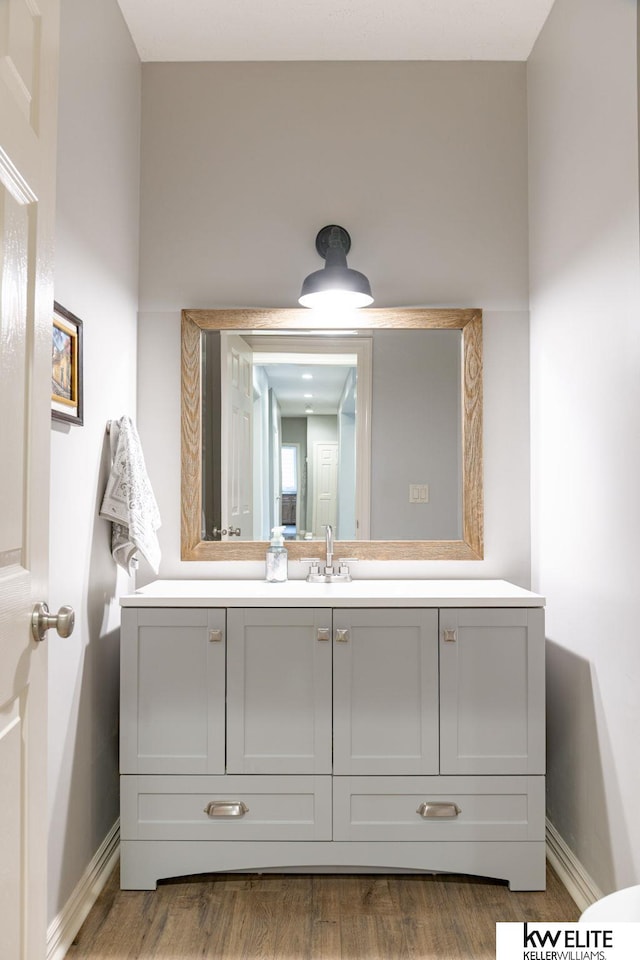 bathroom with vanity, baseboards, and wood finished floors