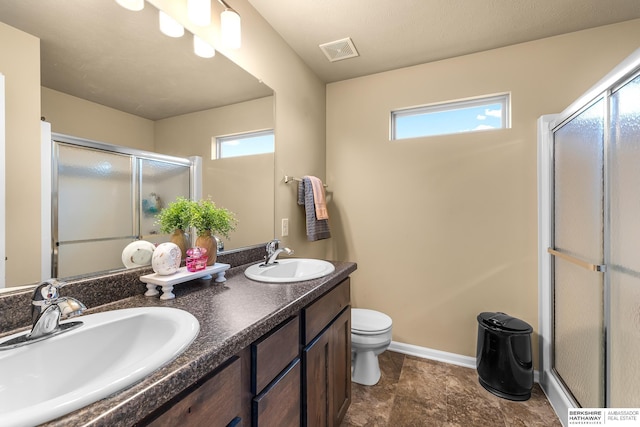 full bath with a sink, a shower stall, toilet, and visible vents