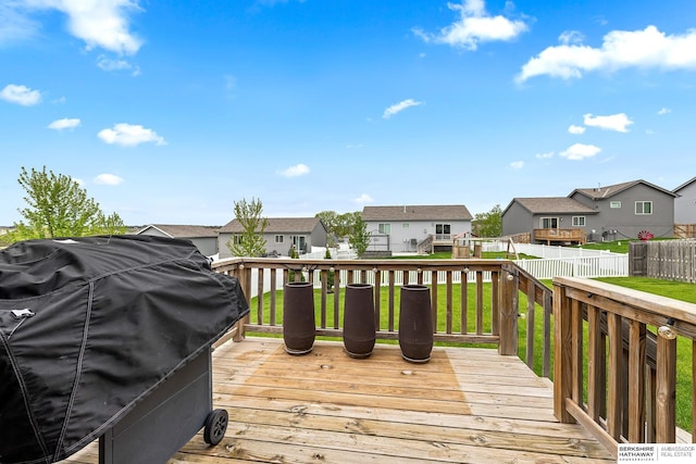 deck featuring a residential view, grilling area, a lawn, and a fenced backyard