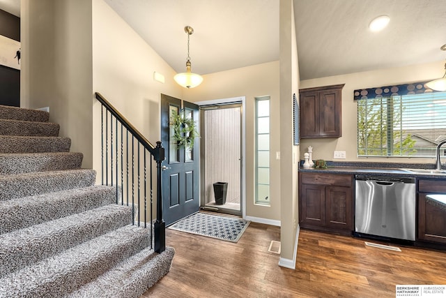 entryway with visible vents, baseboards, stairway, dark wood-type flooring, and vaulted ceiling