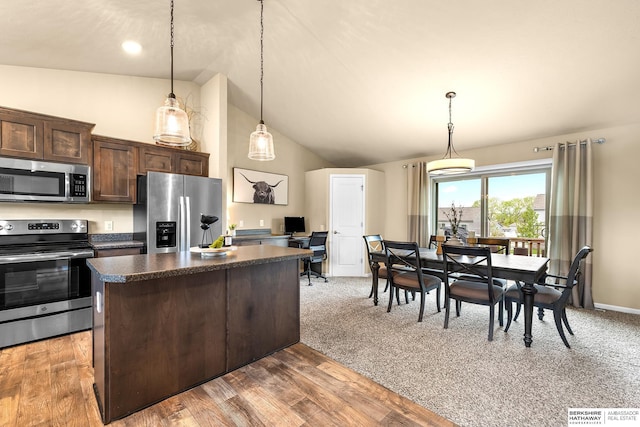 kitchen featuring a kitchen island, dark countertops, vaulted ceiling, dark brown cabinets, and stainless steel appliances