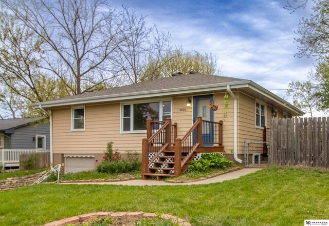 8514 Pinkney St, Omaha, NE 68134 - bungalow featuring fence, a shingled roof, a front yard, and a garage