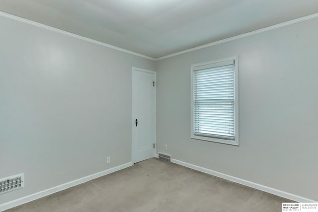 spare room with baseboards, ornamental molding, and visible vents